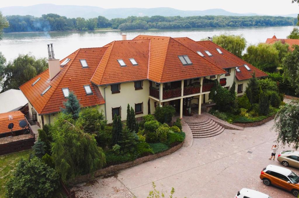 a large house with an orange roof at Camelot Club Hotel in Vác