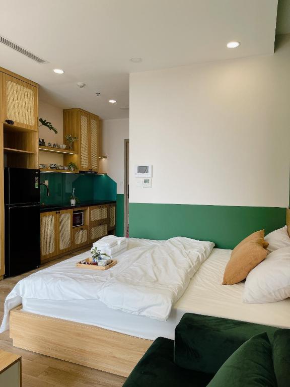 un grande letto bianco in una stanza con parete verde di Mây Homestay Ecopark a HÆ°ng YÃªn