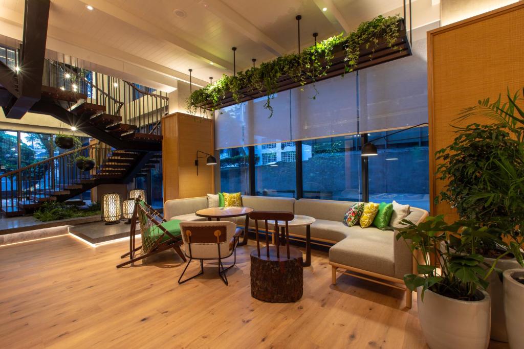 A bright lobby seating area beside tall windows and a feature staircase.