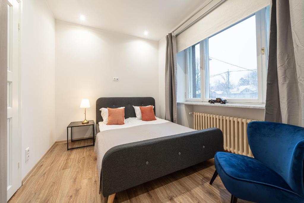 ein Schlafzimmer mit einem Bett und einem blauen Stuhl in der Unterkunft P32 - Boutique City Center Apartments in Tallinn