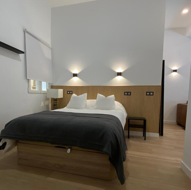 a bedroom with a large bed with a black blanket at Auditorio/Bernabéu Apartment1 in Madrid