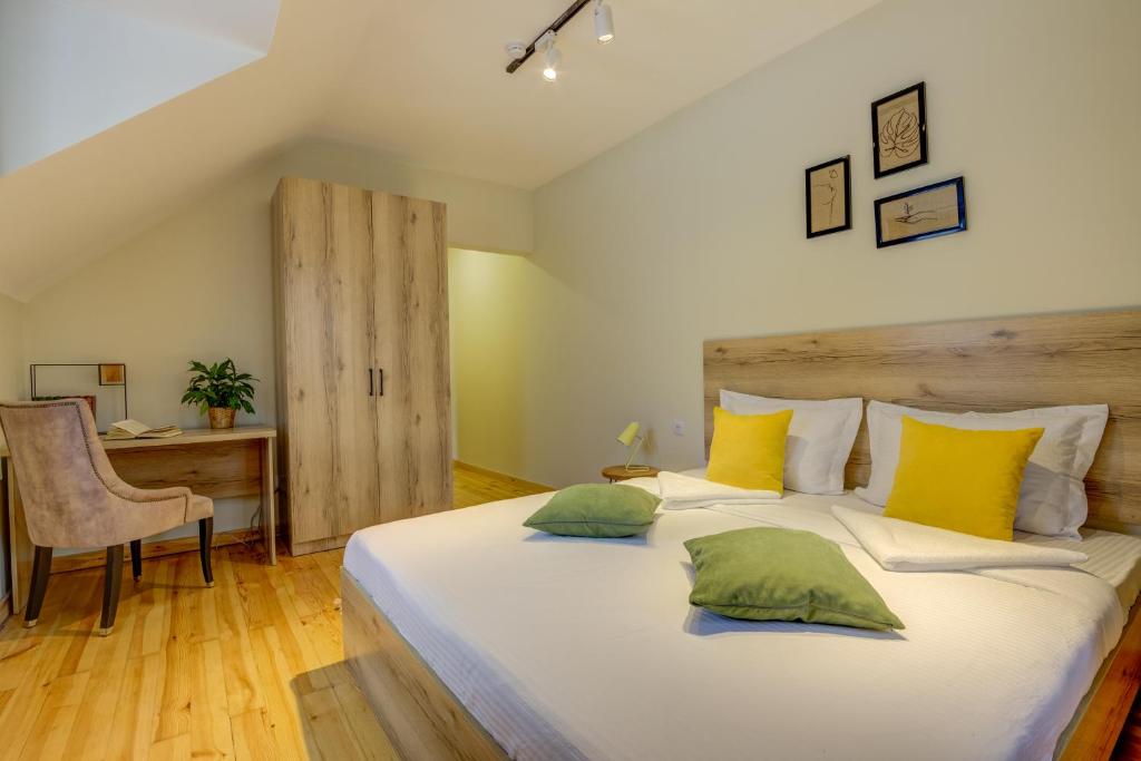 een slaapkamer met een groot bed met gele en groene kussens bij People Guest House in Bisjkek