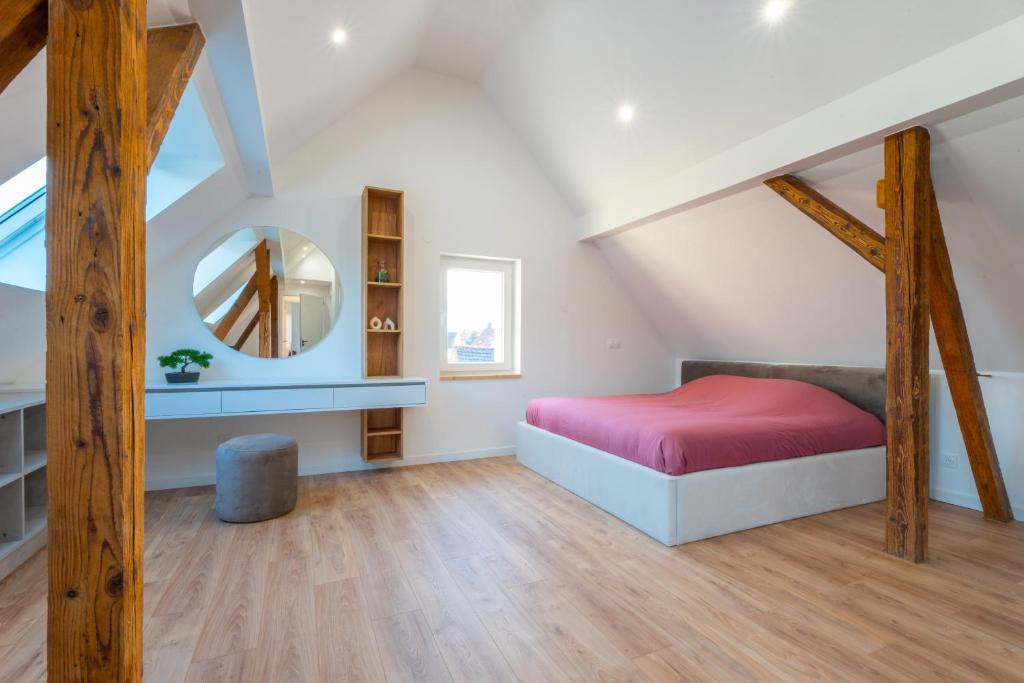 um quarto no sótão com uma cama e um espelho em Magnifique maison neuve em Lingolsheim