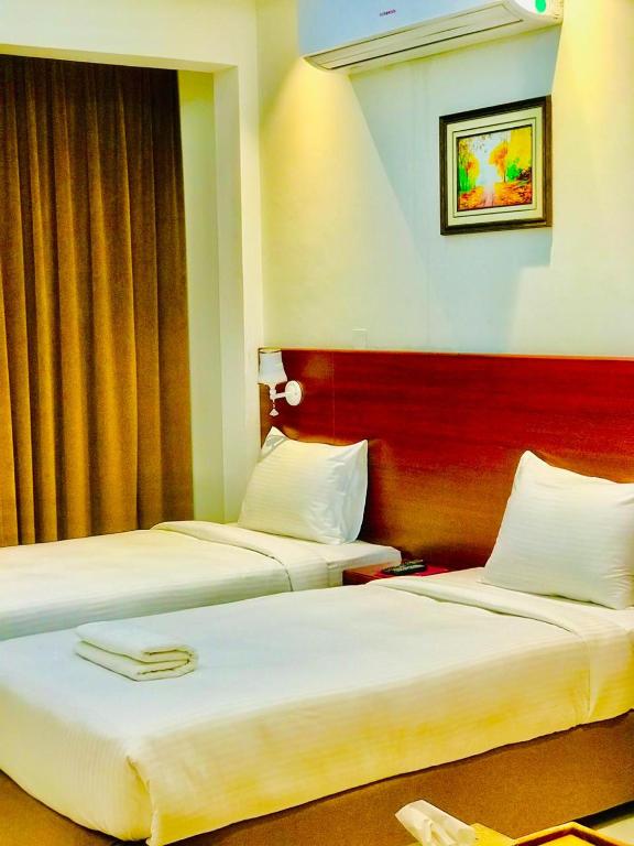 Postel nebo postele na pokoji v ubytování ALJAWHARA INN HOTEL