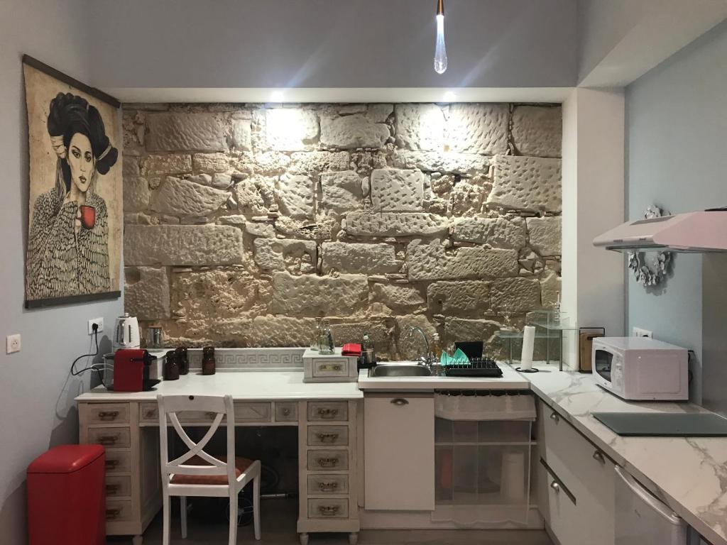 een keuken met een stenen muur op de achtergrond bij L'Apothicaire - BedinShop in Romans-sur-Isère