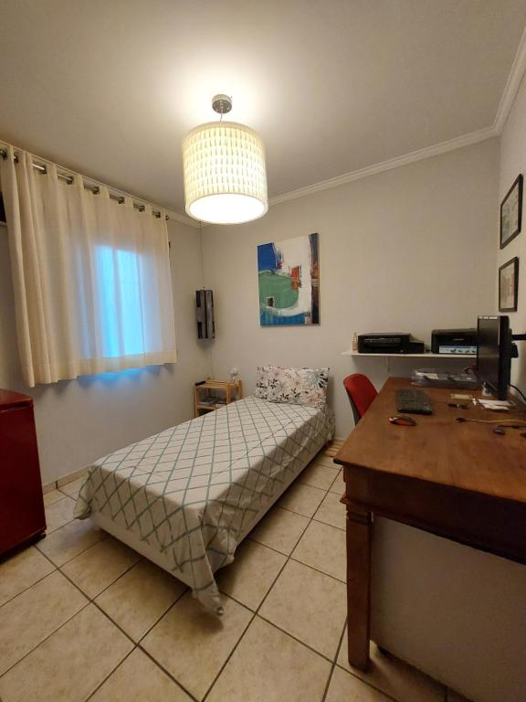 a bedroom with a bed and a table in it at Quando cama Solteiro in Sorocaba