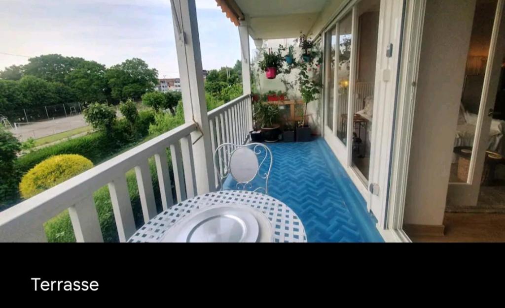 einen Balkon mit einem Tisch und einem Pool auf einer Veranda in der Unterkunft Le bruit des vagues à Trouville sur mer in Trouville-sur-Mer
