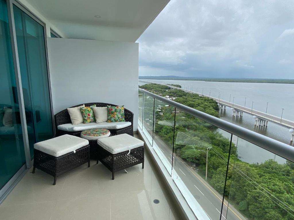 a balcony with a couch and chairs and a view of the water at Apartamentos en Morros Cartagena in Cartagena de Indias