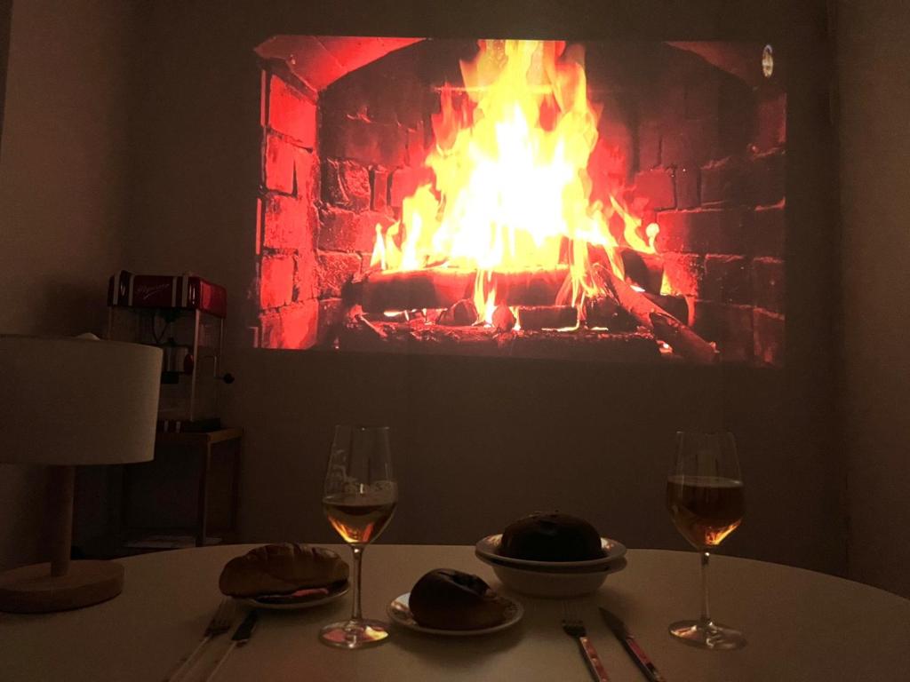 a table with two glasses of wine and a fireplace at Our secret movie theater, Netflix, popcorn, free parking in Seoul