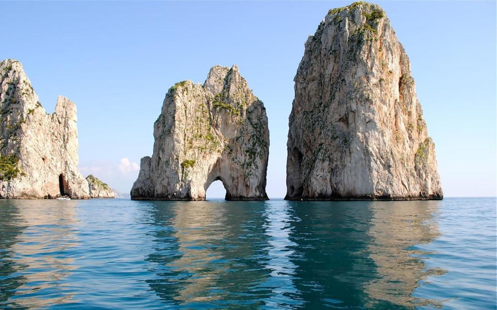 un grupo de rocas grandes en el agua en Studio in pieno centro, en Capri