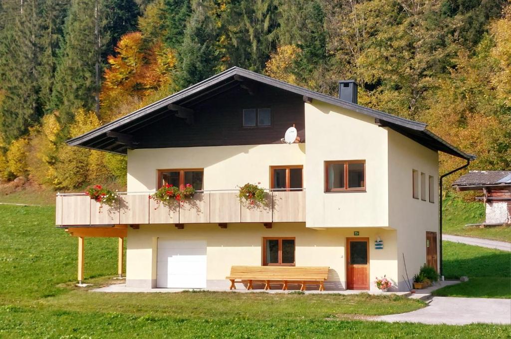 een huis met een houten balkon en een bank bij Ferienhaus am Erlachhof in Söll