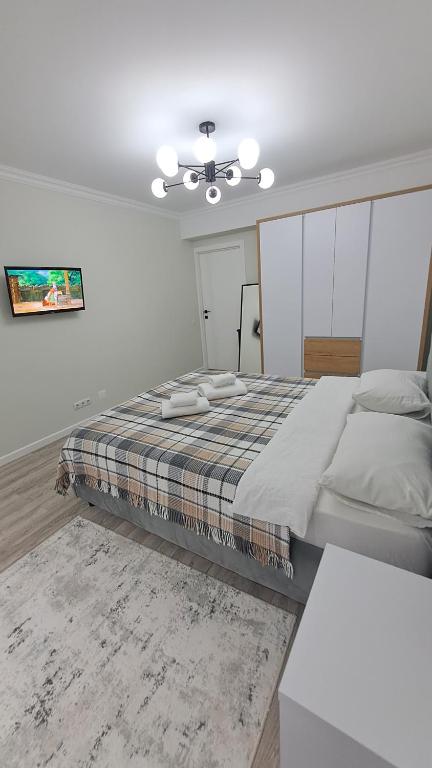 um quarto com uma cama grande e uma ventoinha de tecto em Аэропорт Апартаменты 24&24 em Chisinau