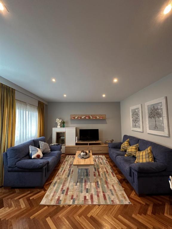 a living room with blue couches and a table at Apartamento Villaluz in Monforte de Lemos