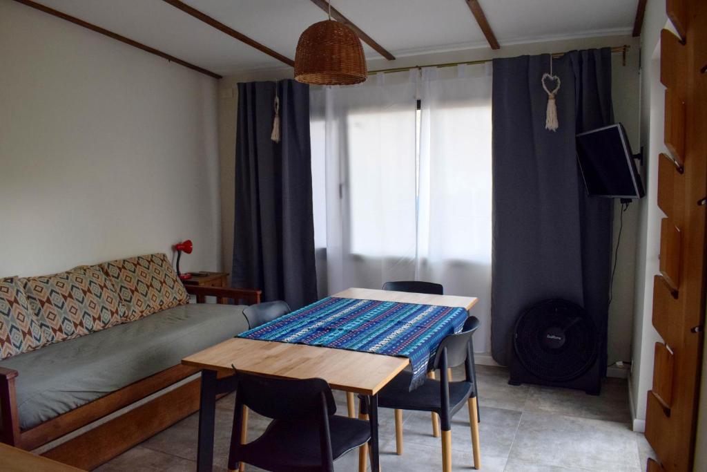 a living room with a table and a couch at La casa del Álamo in Tandil
