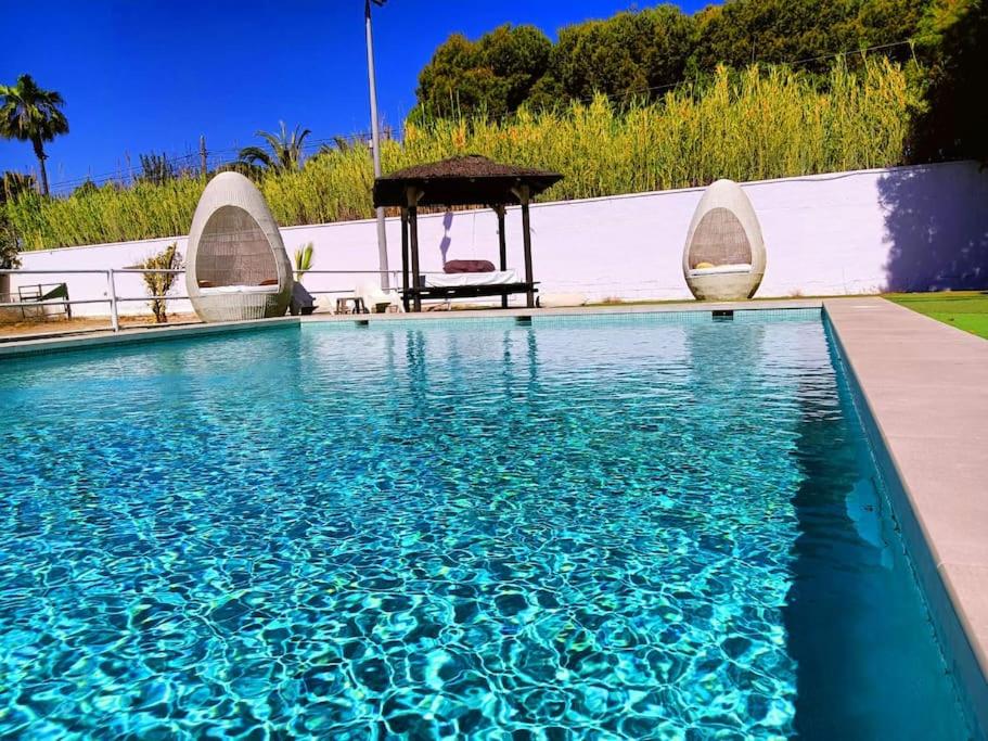 a swimming pool with a chair and a gazebo at Villa La Gran Duquesa in Playa de San Juan