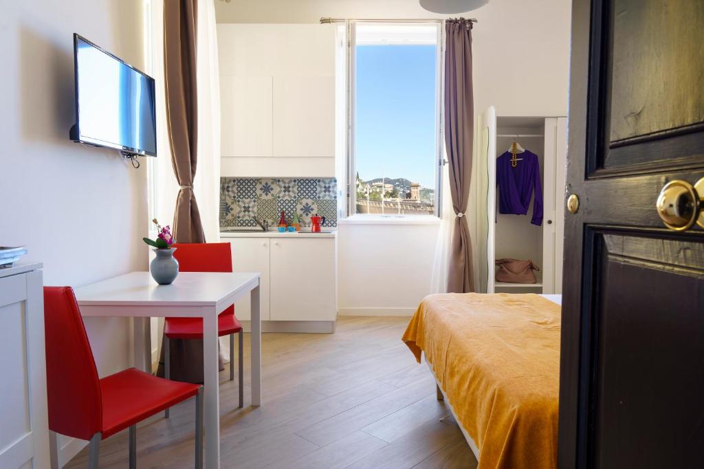 a bedroom with a bed and a table and a window at Palazzo Olivieri Amalfi Coast in Salerno