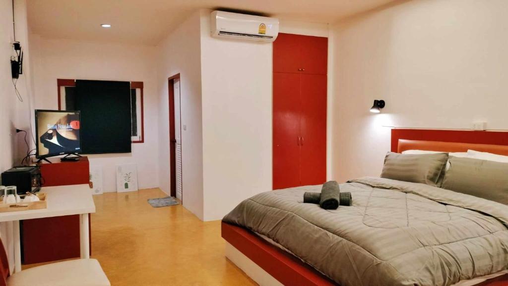 Schlafzimmer mit einem Bett mit rotem Kopfteil in der Unterkunft Mindful Kinesics Wellness Living in Nathon Bay