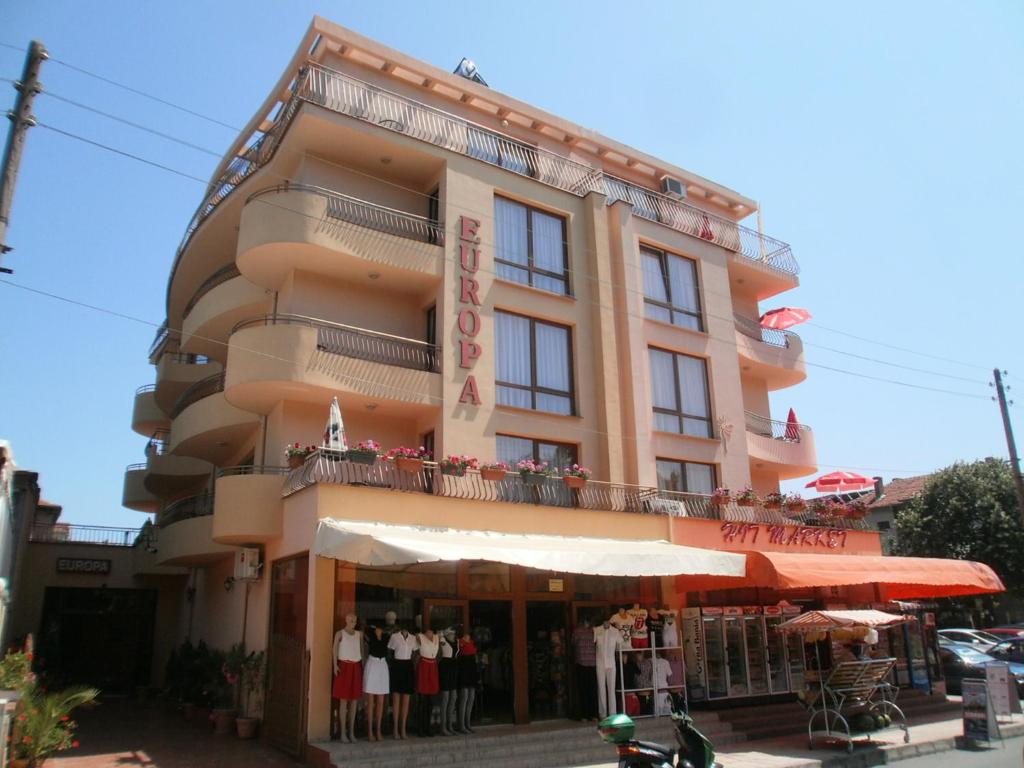 a large building with a store in front of it at EUROPA Guest House in Kiten