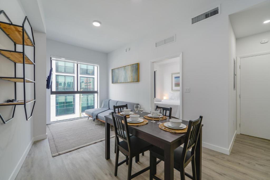 a dining room and living room with a table and chairs at Comfortable Apartment in Charming Wynwood in Miami