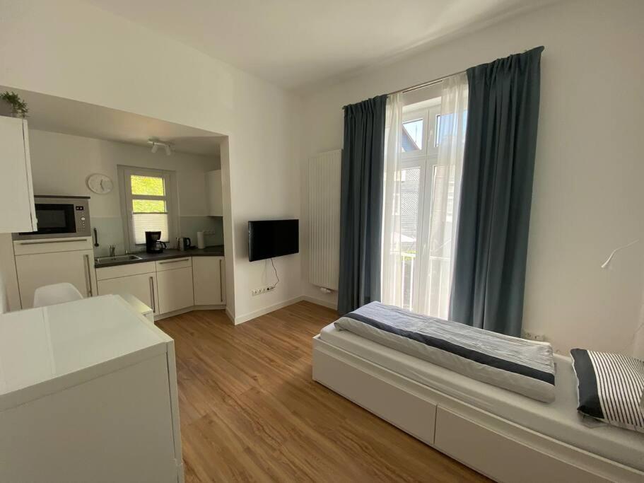 a white room with a bed and a kitchen at Apartment Nr. 2 Bad Laasphe Altstadt in Bad Laasphe