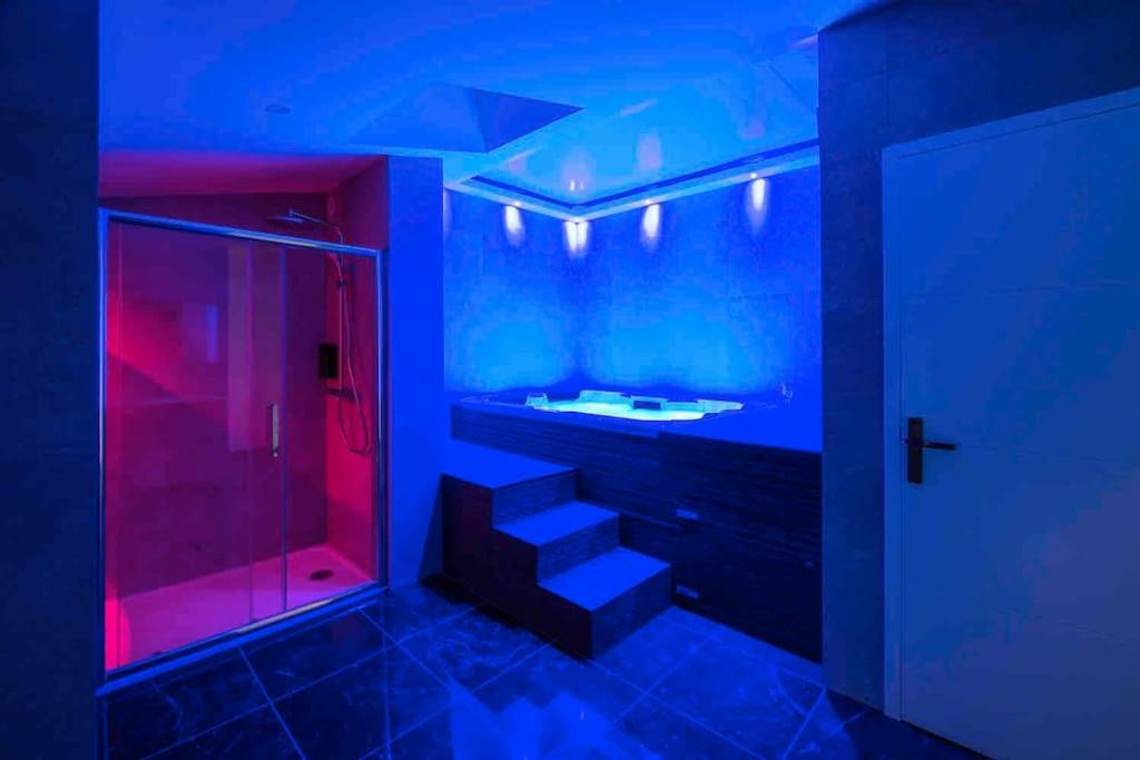 ein blaues und rotes Badezimmer mit einer Dusche und einem Waschbecken in der Unterkunft Appartement jacuzzi hammam in Francheville