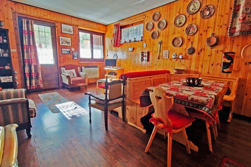 d'une salle à manger avec une table et des murs en bois. dans l'établissement Fionisco - Giardino privato con vista sulle Alpi, à Brusson