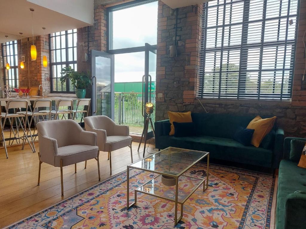 a living room with a couch and chairs and a table at Converted factory loft apartment in Bristol