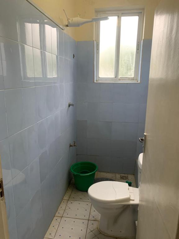 La salle de bains est pourvue de toilettes et d'une fenêtre. dans l'établissement Hismoney1, à Mombasa