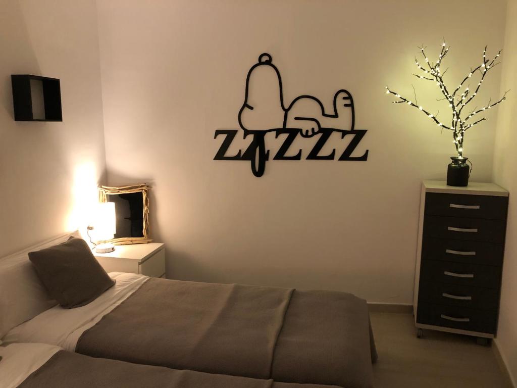 1 dormitorio con 1 cama y un cartel en la pared en APARTAMENTS L’ARC, en Palafrugell