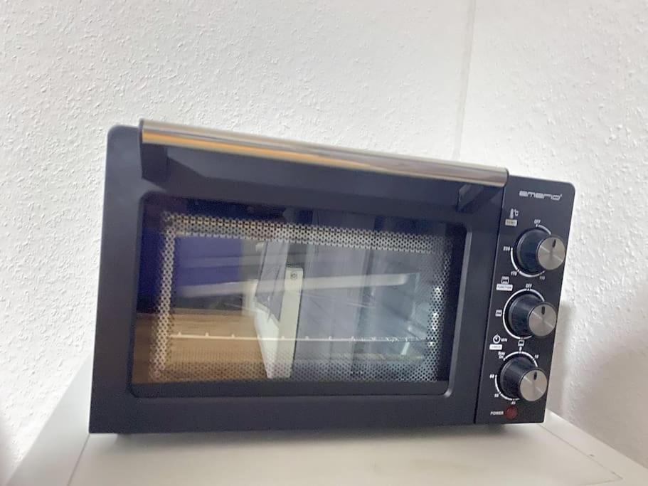 a black microwave sitting on top of a counter at Apartment in Gelsenkirchen - Gemütliche City-Suite in Gelsenkirchen