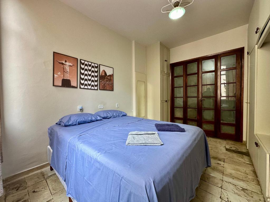 ein Schlafzimmer mit einem Bett mit einer blauen Decke in der Unterkunft Ótimo Apartamento - 500m Praia Copacabana/RJ in Rio de Janeiro