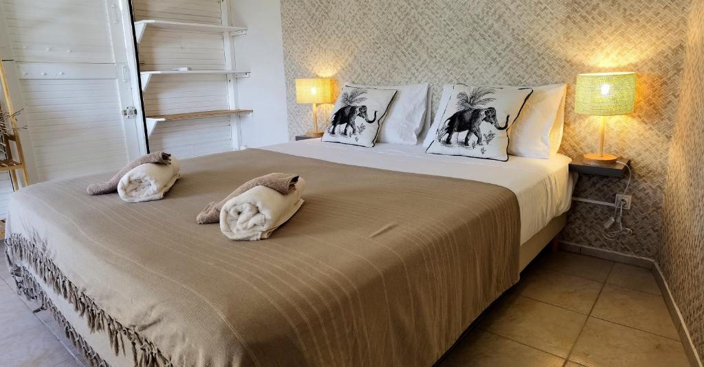 een slaapkamer met 2 katten op een bed bij Coco Carib - Bien Plus Qu'un Hébergement ! in Deshaies