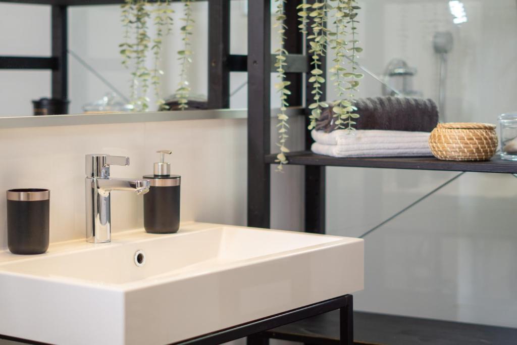 a bathroom with a white sink and a shelf at namastay! - Luxus mit Blick auf den Wasserturm in Mannheim