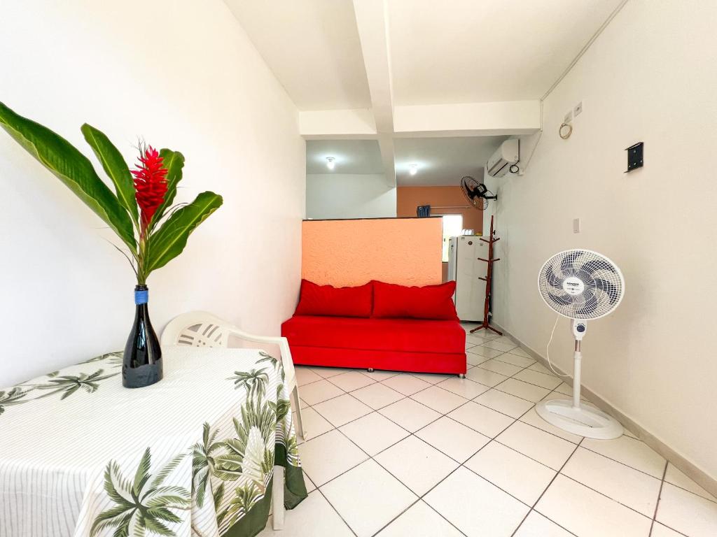 een woonkamer met een rode bank en een ventilator bij Flat Completo no Centro de Itacaré in Itacaré