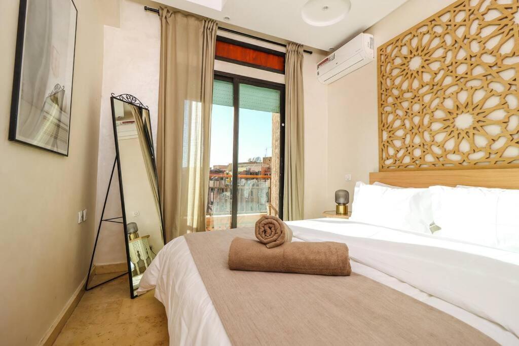 Schlafzimmer mit einem Bett und einem großen Fenster in der Unterkunft En plein Cœur de Gueliz in Marrakesch