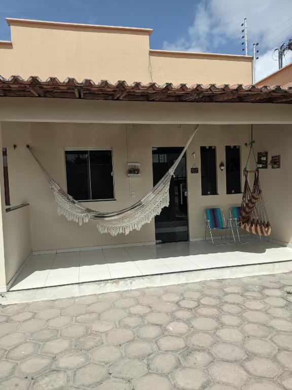 a house with a hammock on the side of it at Lençóis Dunas Residence 1 in Santo Amaro