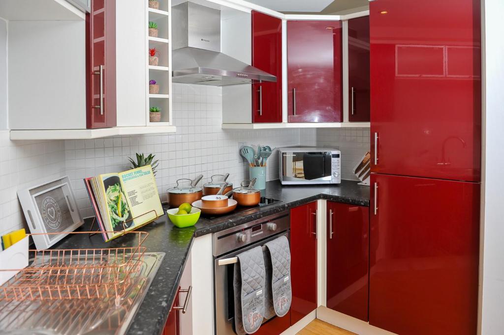 een keuken met rode kasten en een rode koelkast bij The Pavilions by Select SA in Windsor
