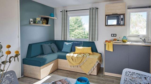 salon z niebieską kanapą w kuchni w obiekcie Camping pays de Beille w mieście Les Cabannes