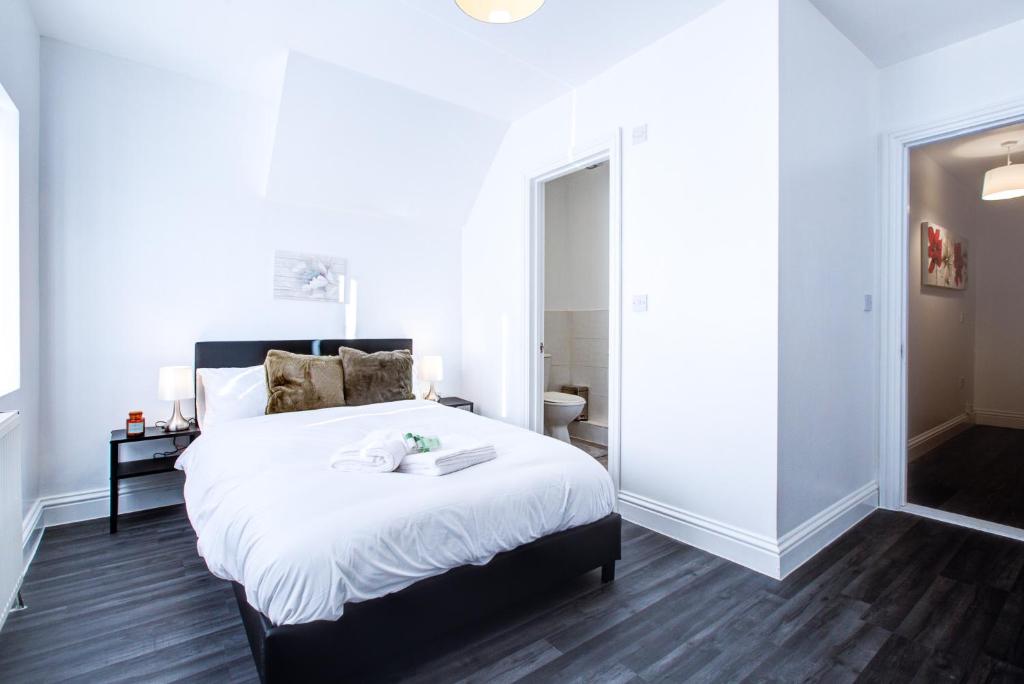 um quarto com uma grande cama branca e um espelho em Modern 6 Bed 3 Bath House em Colchester