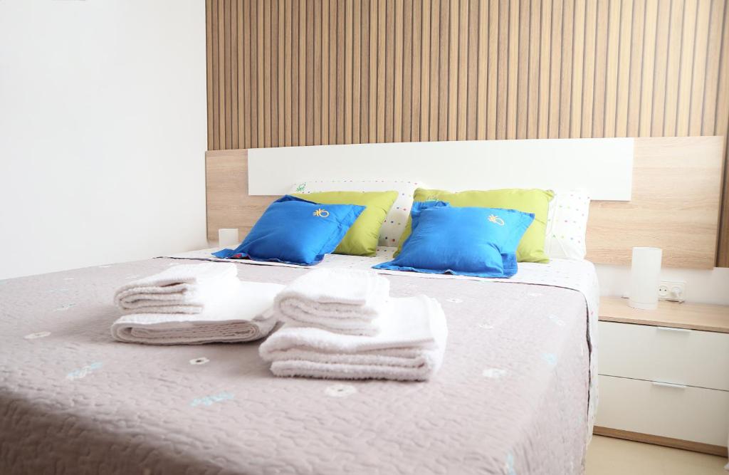 1 dormitorio con 1 cama con toallas y almohadas azules en HAPPY FLAT TENERIFE, en San Isidro