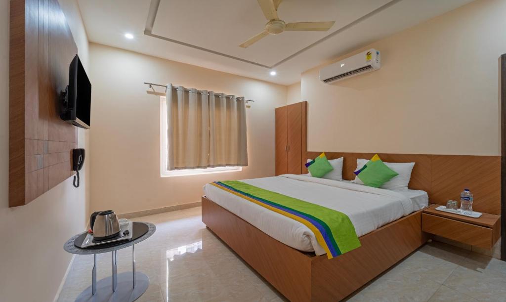 a bedroom with a bed and a television in a room at Treebo Trend Raj Palace in Varanasi