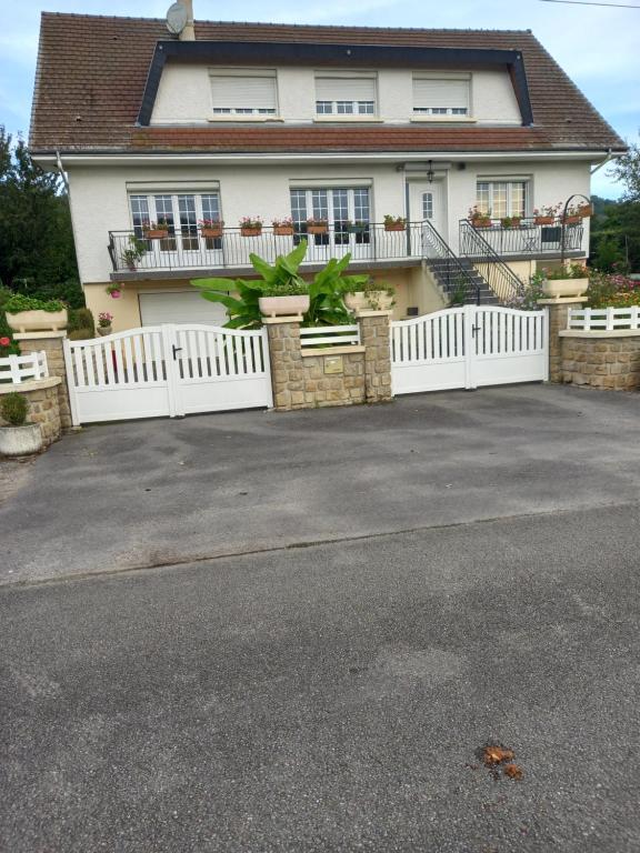 a white fence in front of a house at au jardin Fessard in Fagnon