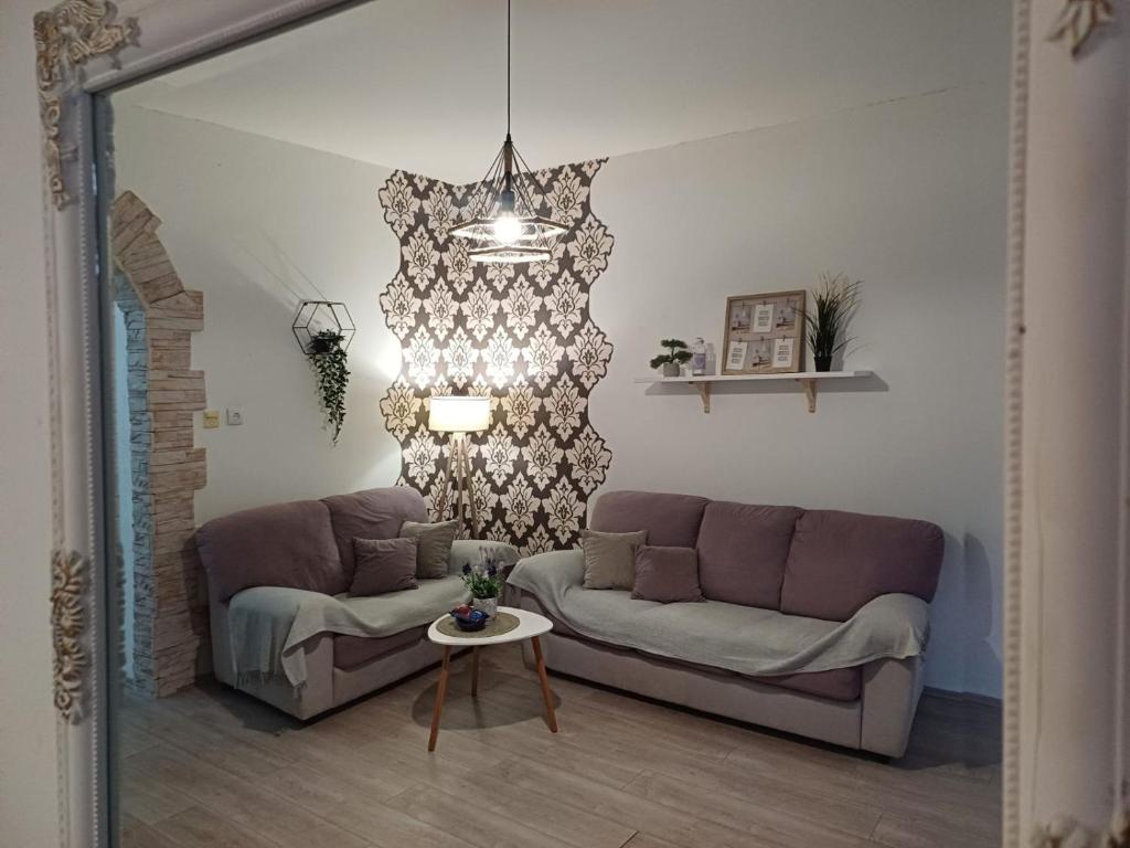 uma sala de estar com um sofá e uma mesa em Apartment Green Free private parking em Novi Sad