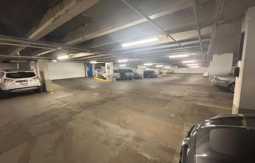 een parkeergarage met meerdere auto's erin geparkeerd bij 2 Full Beds, Free Parking Underground Heated, Rogers Place, 1 Bedroom Condo Downtown Central in Edmonton