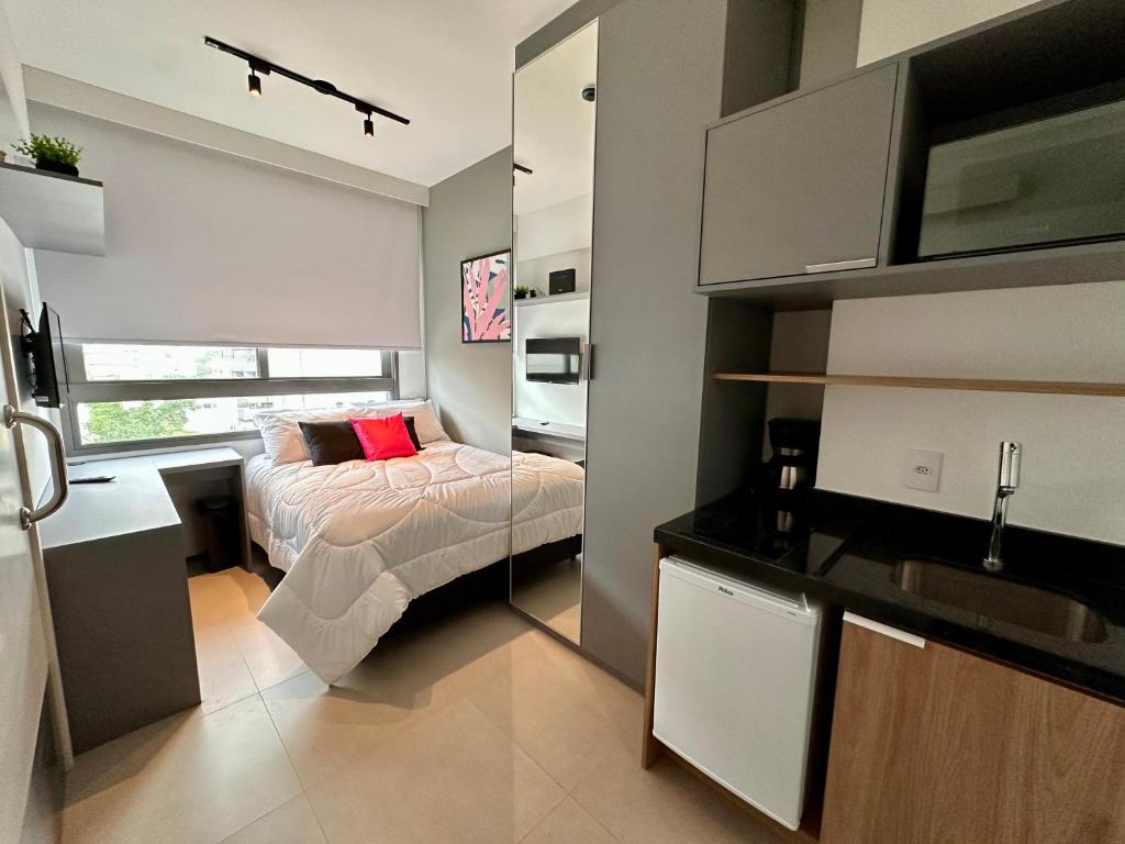 a small bedroom with a bed and a kitchen at Studio São Paulo ao lado do Allianz parque in Sao Paulo