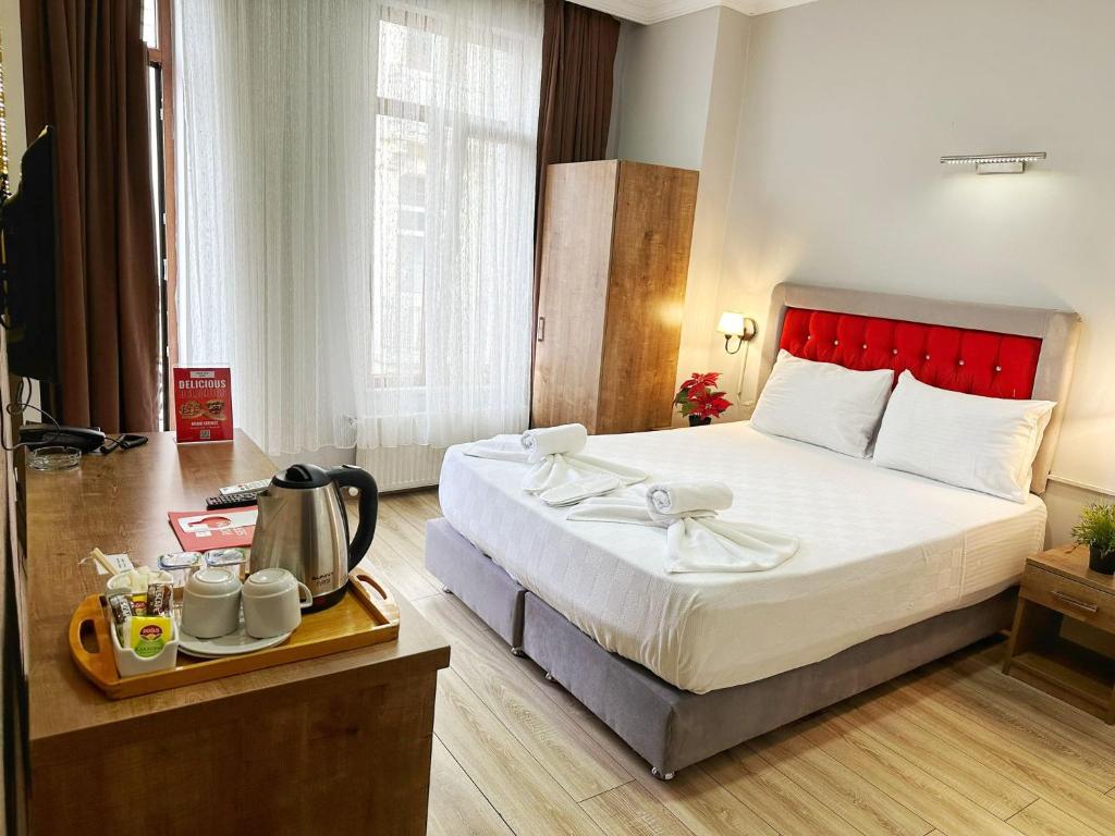 イスタンブールにあるTaksim Park Suitesのベッド1台、トレイ(ティーポット付)
