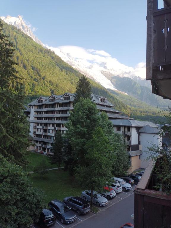 un parking avec des voitures garées devant un bâtiment dans l'établissement Chez moi, à Chamonix-Mont-Blanc