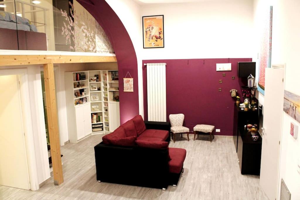sala de estar con sofá y pared púrpura en PURPLE HOUSE, en Roma