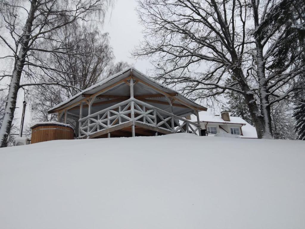 a building in the snow with trees in the background at Vana-Vastseliina külalistemaja in Illi