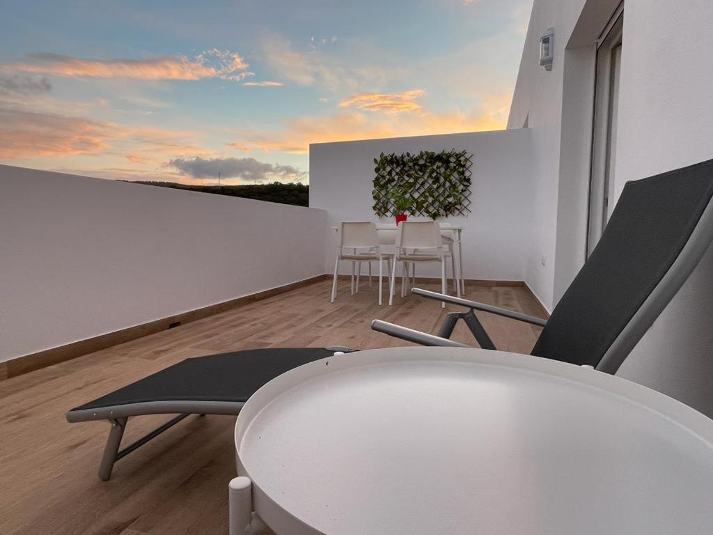 a room with a table and chairs and a white wall at Ático Laan en Setenil de las Bodegas in Setenil